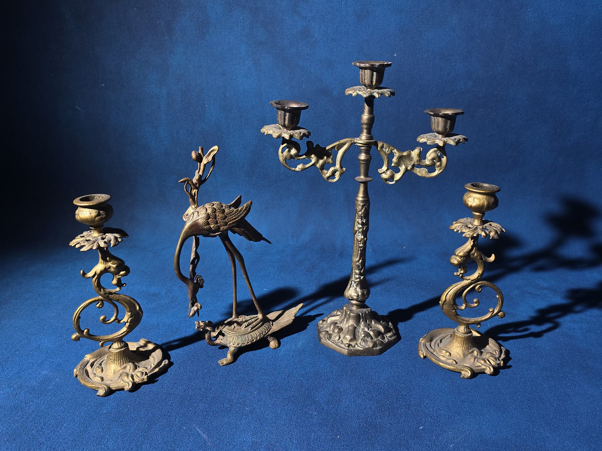 Grouping of Four Antique and Vintage Brass Candleholders including Crane on Turtle Figure, Three-Arm Candelabra, and Pair of Candlesticks