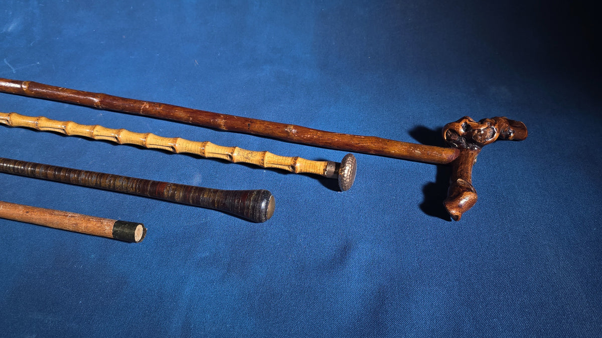 Grouping of Four Antique Walking Canes including Bamboo Cane with Hammered Metal Knob Handle and Engraved Monogram, Burl Wood Cane, and Leather-Wrapped Cane