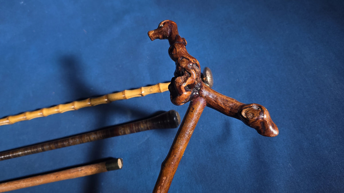 Grouping of Four Antique Walking Canes including Bamboo Cane with Hammered Metal Knob Handle and Engraved Monogram, Burl Wood Cane, and Leather-Wrapped Cane
