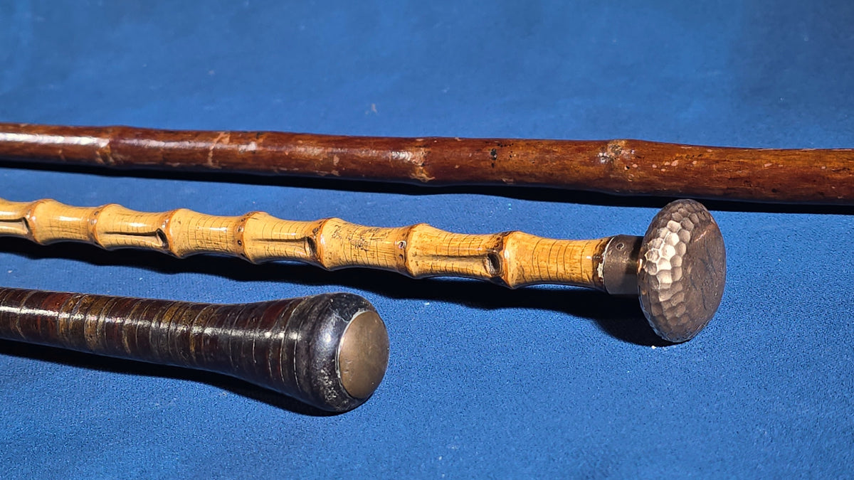 Grouping of Four Antique Walking Canes including Bamboo Cane with Hammered Metal Knob Handle and Engraved Monogram, Burl Wood Cane, and Leather-Wrapped Cane
