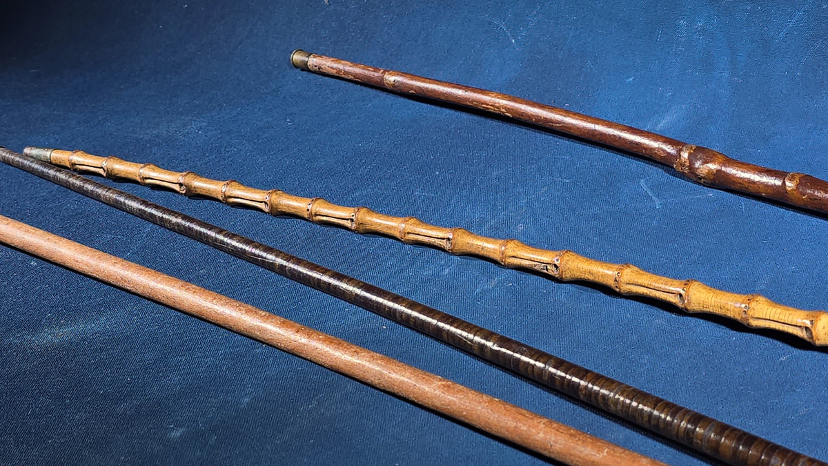 Grouping of Four Antique Walking Canes including Bamboo Cane with Hammered Metal Knob Handle and Engraved Monogram, Burl Wood Cane, and Leather-Wrapped Cane