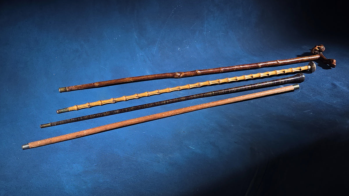 Grouping of Four Antique Walking Canes including Bamboo Cane with Hammered Metal Knob Handle and Engraved Monogram, Burl Wood Cane, and Leather-Wrapped Cane
