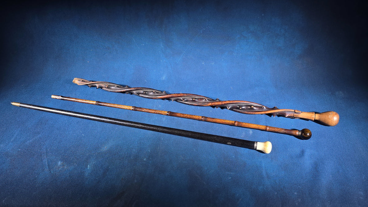 Trio of Antique Walking Canes including Carved Twisted Wood, Bamboo with Tiger's Eye Ball Top, and Ivory-Topped Ebony