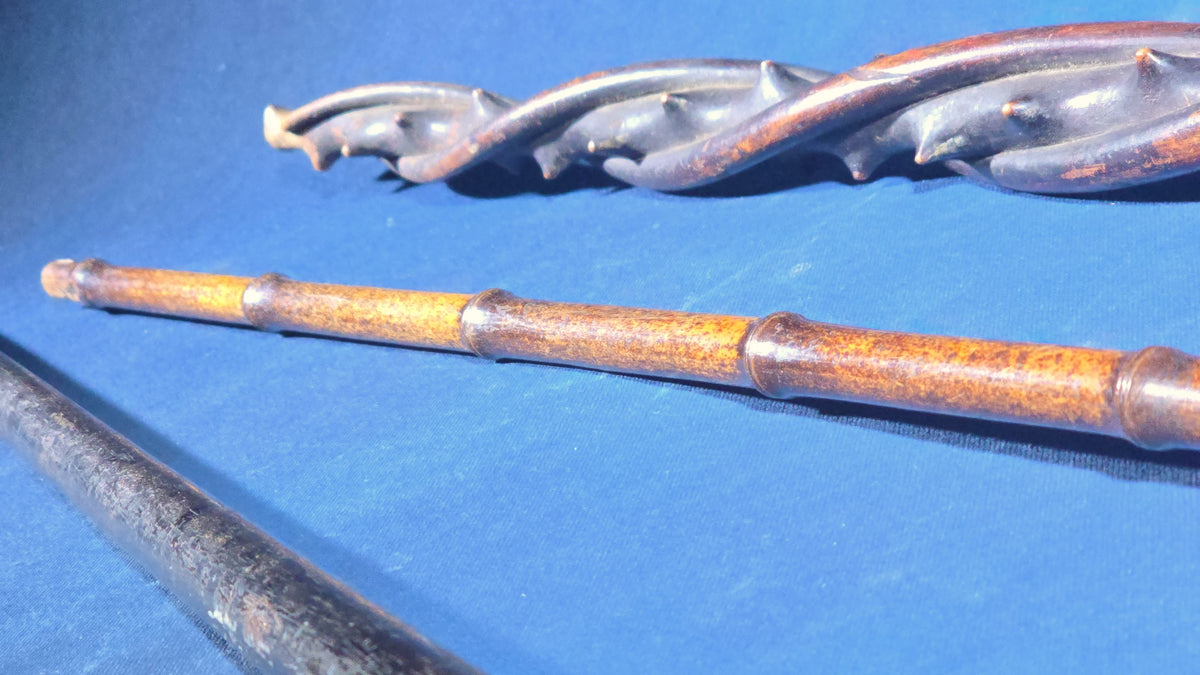 Trio of Antique Walking Canes including Carved Twisted Wood, Bamboo with Tiger's Eye Ball Top, and Ivory-Topped Ebony
