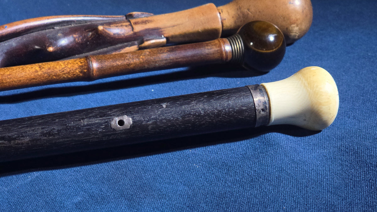 Trio of Antique Walking Canes including Carved Twisted Wood, Bamboo with Tiger's Eye Ball Top, and Ivory-Topped Ebony