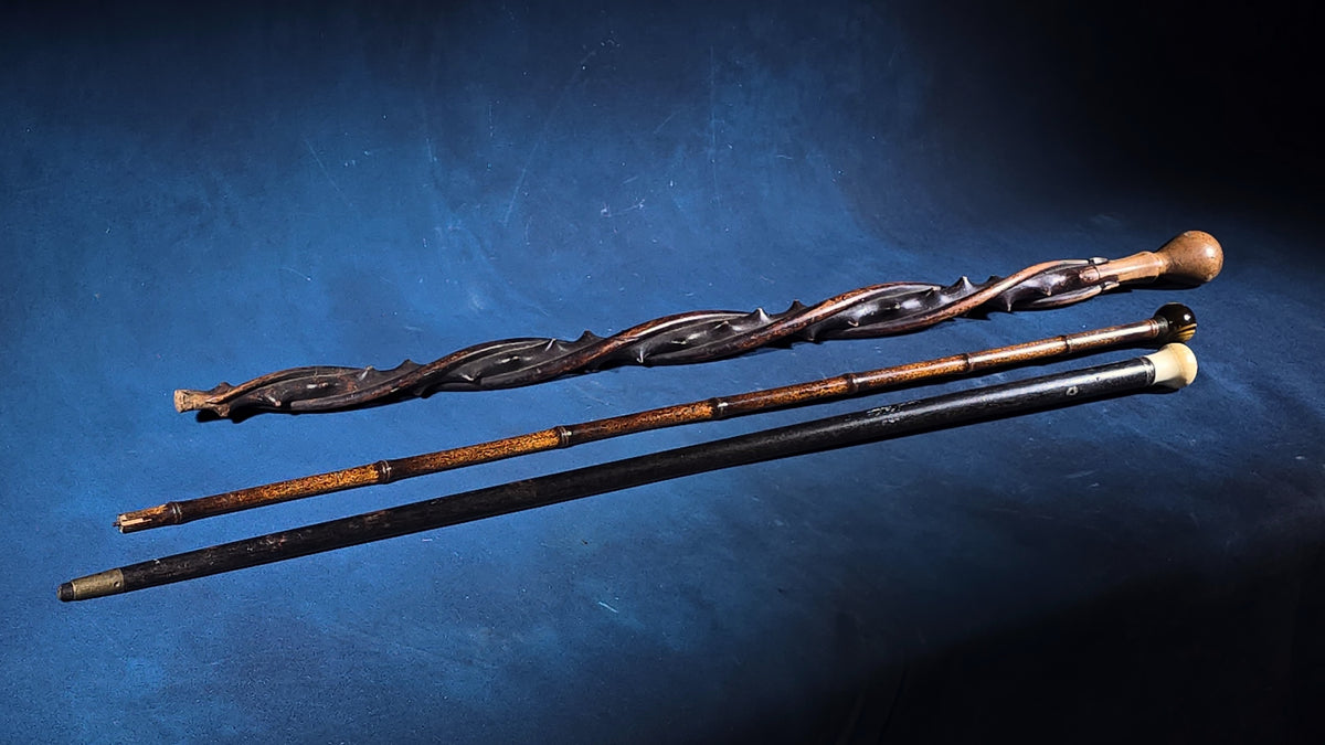 Trio of Antique Walking Canes including Carved Twisted Wood, Bamboo with Tiger's Eye Ball Top, and Ivory-Topped Ebony