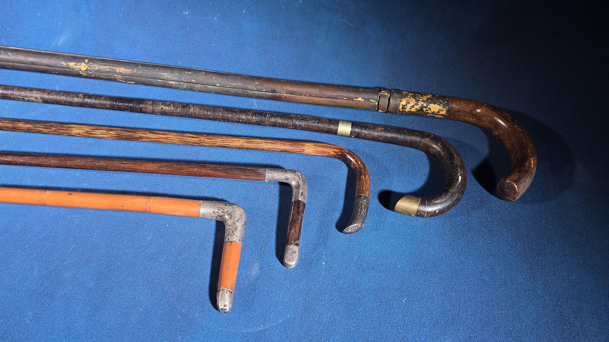 Grouping of Five Antique and Vintage Walking Canes including Tripod Cane, Sterling Silver-Mounted Examples, and Bamboo