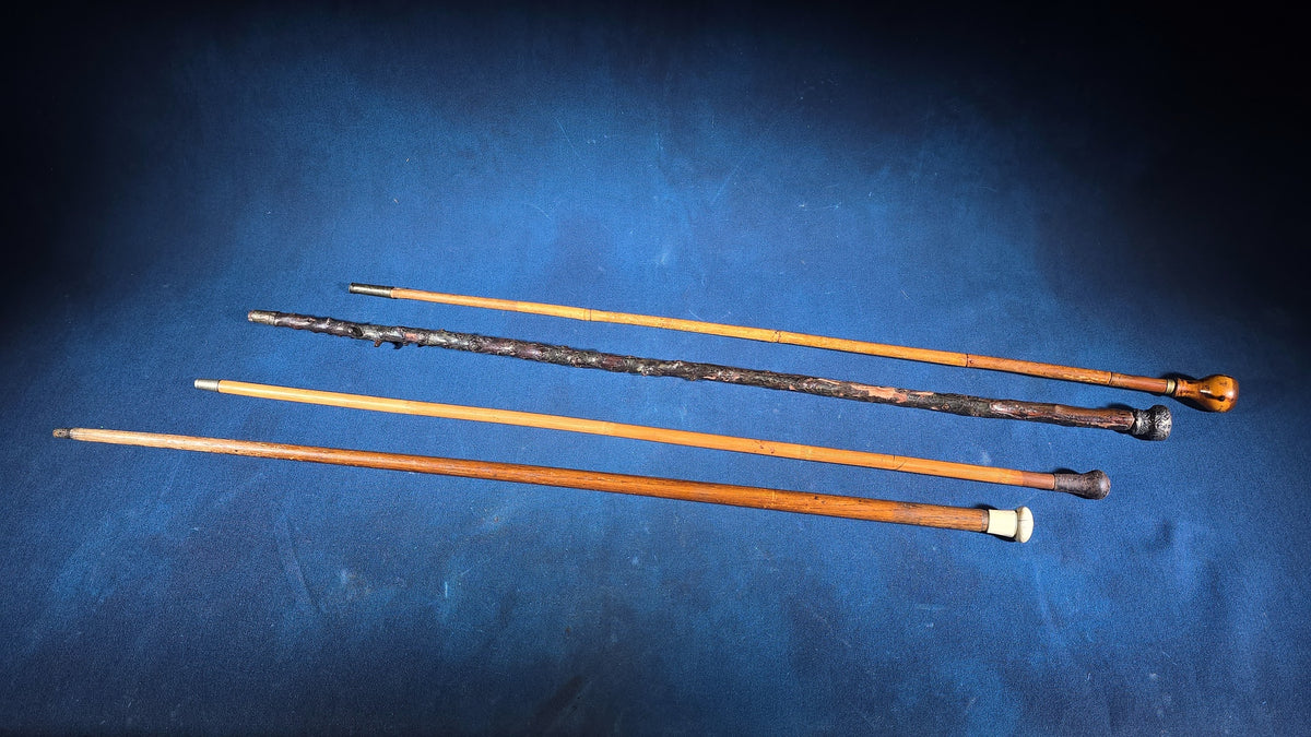 Grouping of Four Antique Walking Canes including Knotted Wood with Monogrammed Sterling Silver Knob, Bamboo with Glass-Topped Compass Handle, and Bone-Topped Wooden Cane