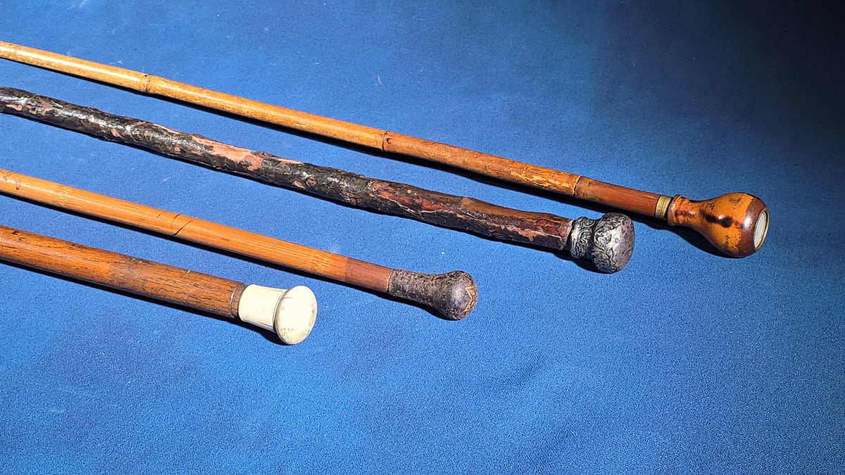 Grouping of Four Antique Walking Canes including Knotted Wood with Monogrammed Sterling Silver Knob, Bamboo with Glass-Topped Compass Handle, and Bone-Topped Wooden Cane