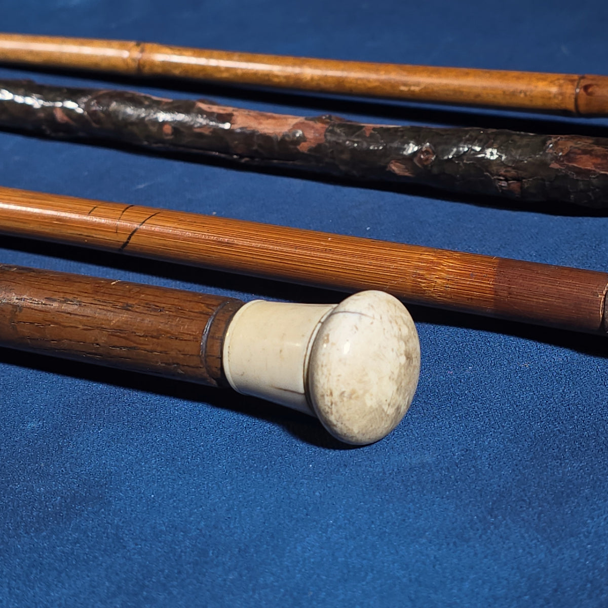 Grouping of Four Antique Walking Canes including Knotted Wood with Monogrammed Sterling Silver Knob, Bamboo with Glass-Topped Compass Handle, and Bone-Topped Wooden Cane