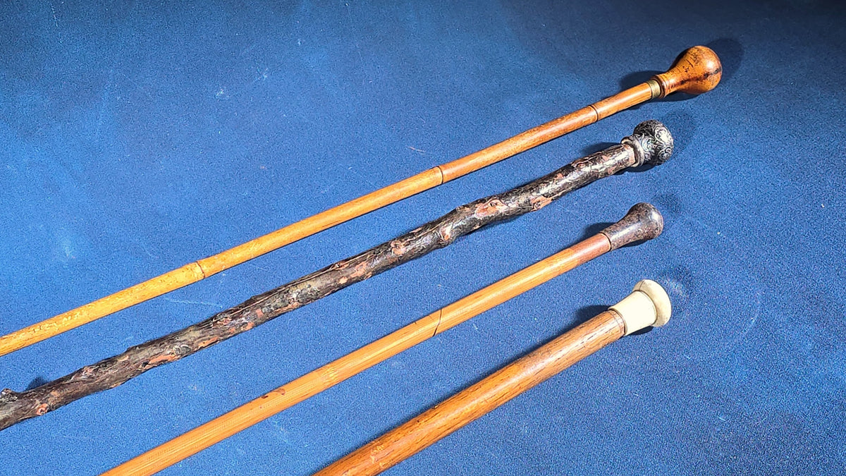 Grouping of Four Antique Walking Canes including Knotted Wood with Monogrammed Sterling Silver Knob, Bamboo with Glass-Topped Compass Handle, and Bone-Topped Wooden Cane