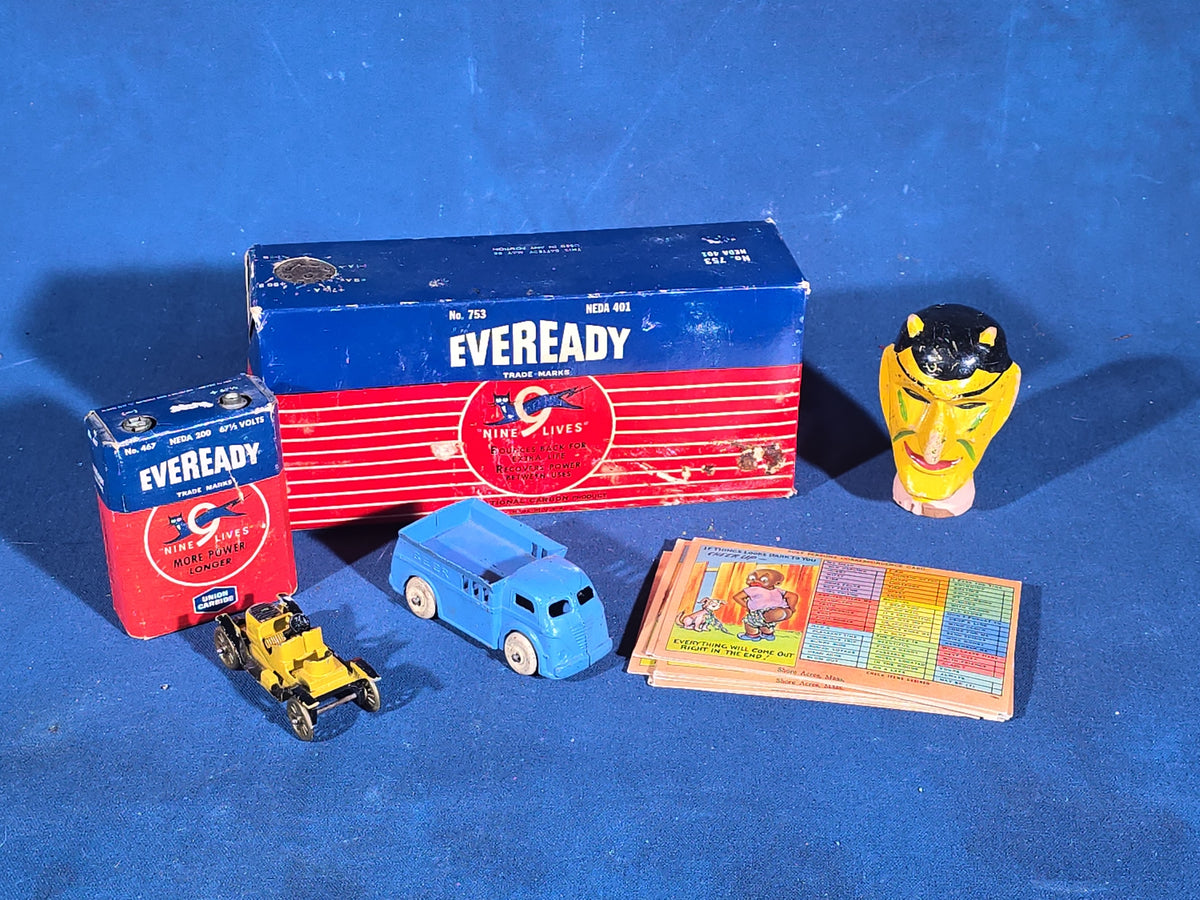 Grouping of Vintage Smalls including Eveready Nine Lives Batteries, Cast Metal Toy Cars, Carved Wooden Devil Head, and Postcards