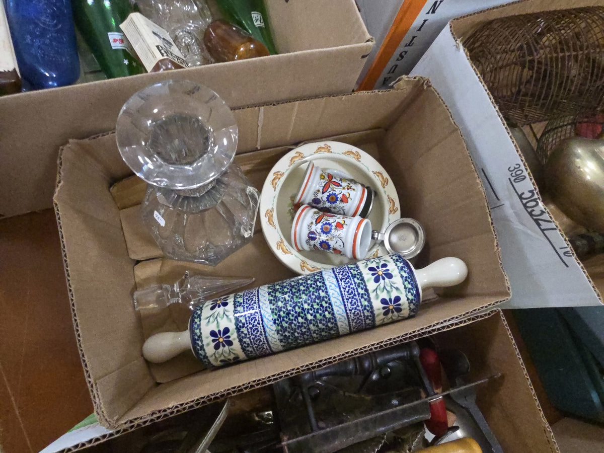 box lot of porcelain items including rolling pin, mini steins, children's plate, and crystal decanter