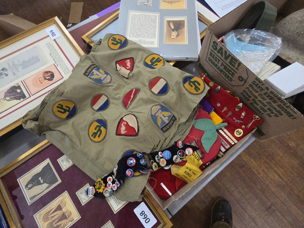 grouping of military patches sewn on to fabric along with pins and other collectibles