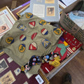 Lot 069 - Grouping of Military Patches Sewn on to Fabric Along with Pins and Other Collectibles