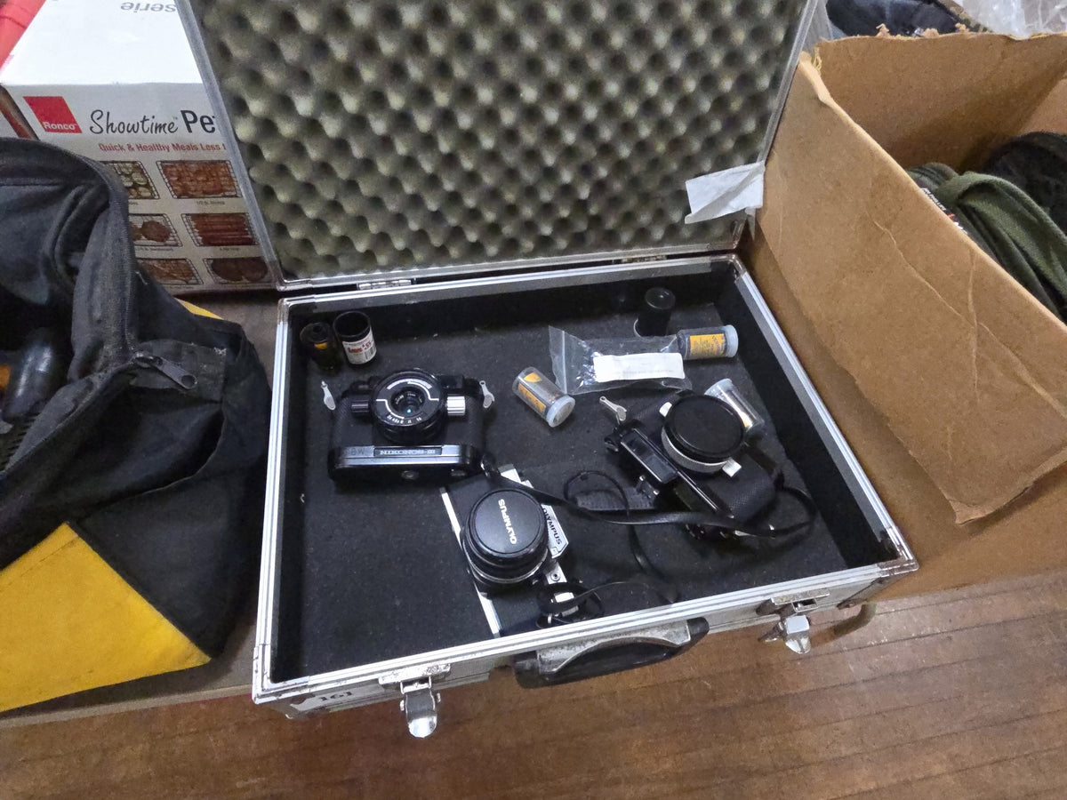 metal carry case with miscellaneous cameras including Olympus and Nikon