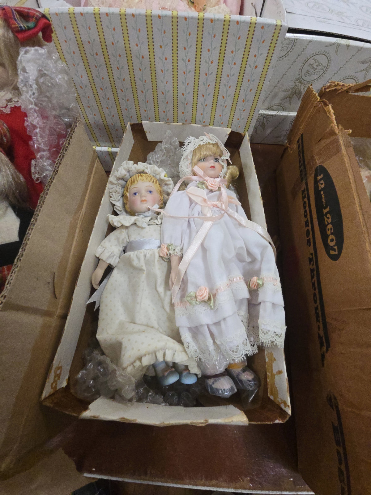 two porcelain dolls in box with bonnets
