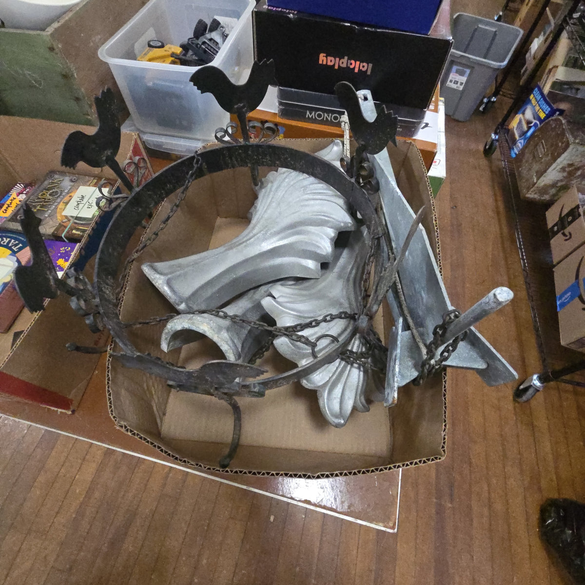 box lot of metal objects including hanging fixture, three aluminum legs, and anchor