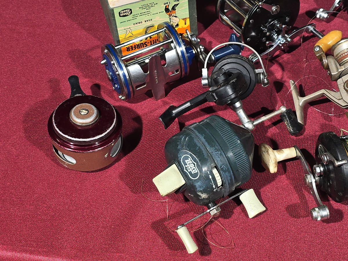 Grouping of 20+ Vintage and Modern Fishing Reels Including Penn Long Beach No. 60, Penn Jigmaster No. 500, Penn No. 155, Penn Hi-Surfer No. 160, Olympic Dolphin 612, Ocean City 113, South Bend Automatic, Abu Garcia Ambassadeur 6000, and More