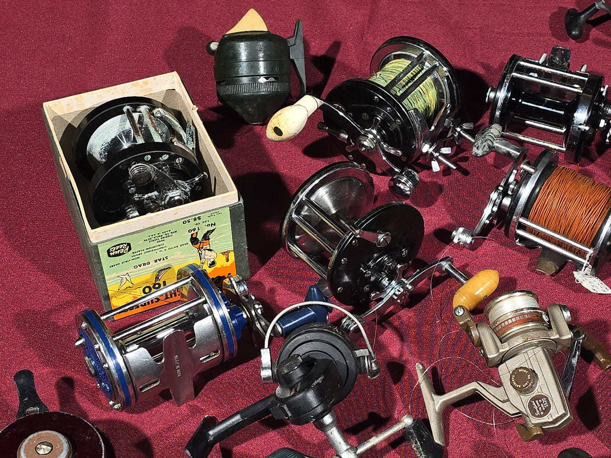 Grouping of 20+ Vintage and Modern Fishing Reels Including Penn Long Beach No. 60, Penn Jigmaster No. 500, Penn No. 155, Penn Hi-Surfer No. 160, Olympic Dolphin 612, Ocean City 113, South Bend Automatic, Abu Garcia Ambassadeur 6000, and More