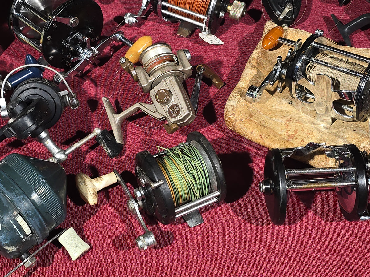 Grouping of 20+ Vintage and Modern Fishing Reels Including Penn Long Beach No. 60, Penn Jigmaster No. 500, Penn No. 155, Penn Hi-Surfer No. 160, Olympic Dolphin 612, Ocean City 113, South Bend Automatic, Abu Garcia Ambassadeur 6000, and More
