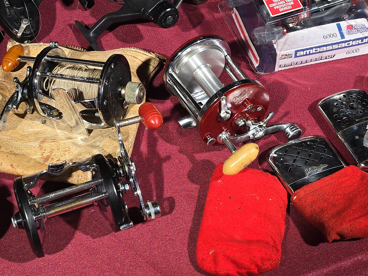 Grouping of 20+ Vintage and Modern Fishing Reels Including Penn Long Beach No. 60, Penn Jigmaster No. 500, Penn No. 155, Penn Hi-Surfer No. 160, Olympic Dolphin 612, Ocean City 113, South Bend Automatic, Abu Garcia Ambassadeur 6000, and More