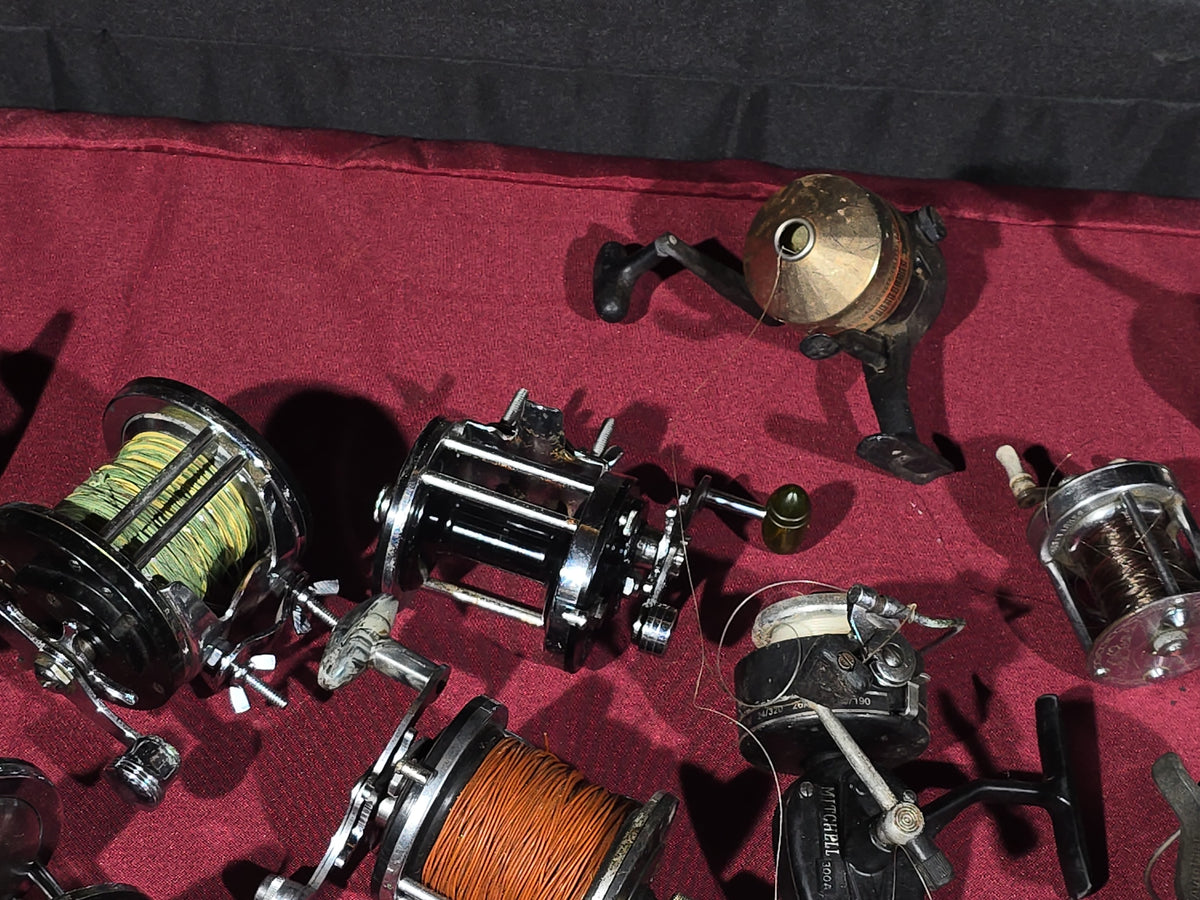 Grouping of 20+ Vintage and Modern Fishing Reels Including Penn Long Beach No. 60, Penn Jigmaster No. 500, Penn No. 155, Penn Hi-Surfer No. 160, Olympic Dolphin 612, Ocean City 113, South Bend Automatic, Abu Garcia Ambassadeur 6000, and More