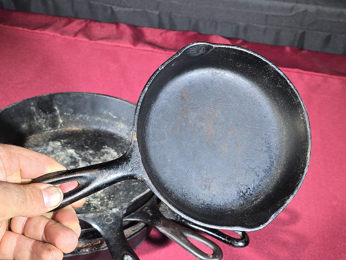 Grouping of Five Antique and Vintage Cast Iron Skillets including Griswold No. 7, Wagner Ware No. 8, and Wapak No. 8