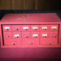 Lot 220 - Vintage Pink-Painted Wooden Parts Cabinet with 18 Metal Drawers and Handwritten Labels, 19-3/8" L x 8-1/2" H
