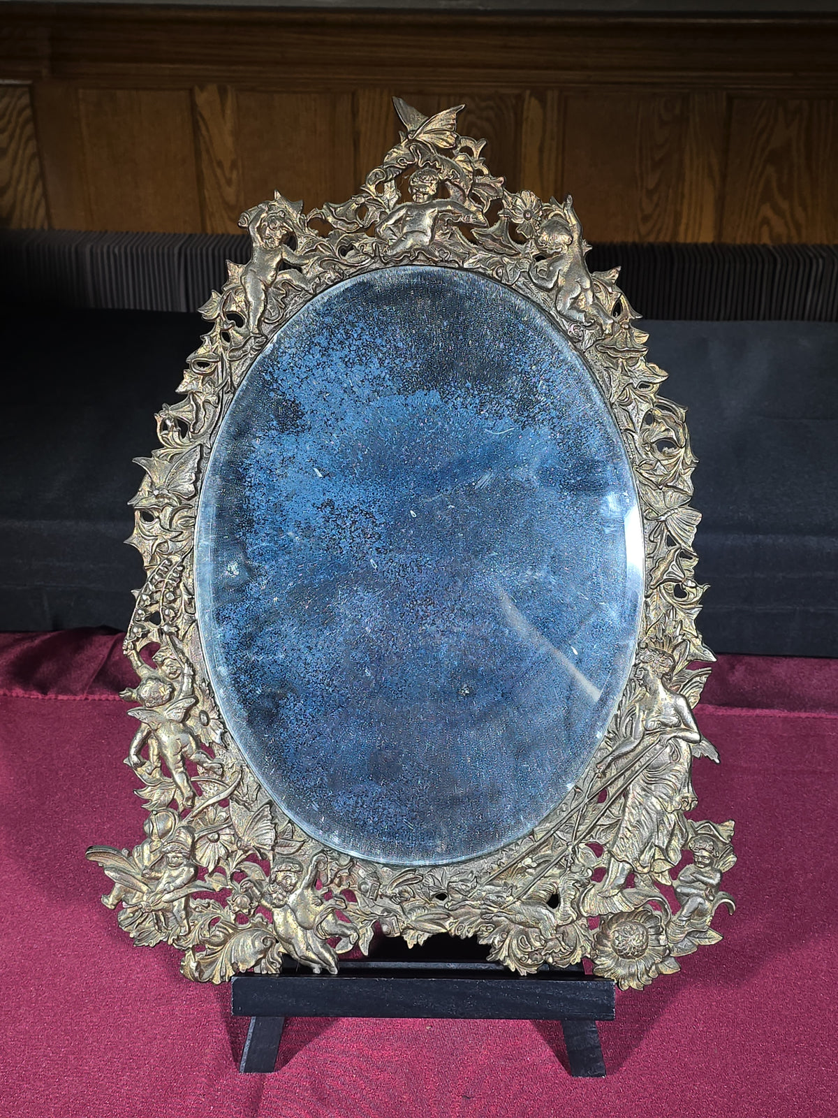 Antique Cast Brass Oval Mirror with Figural Cherub and Floral Surround