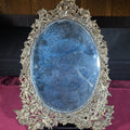 Lot 212 - Antique Cast Brass Oval Mirror with Figural Cherub and Floral Surround, 13" W x 17" H