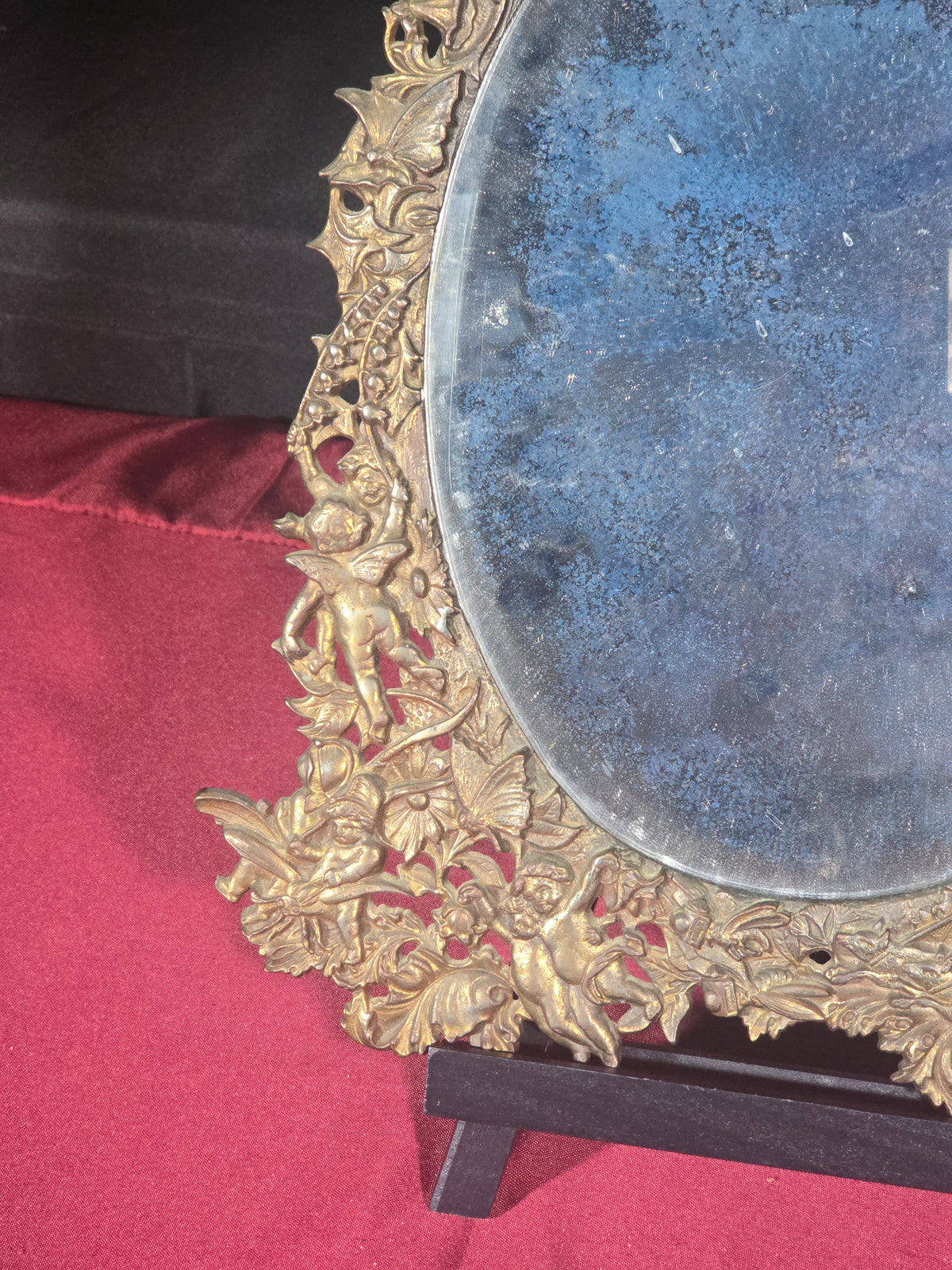 Antique Cast Brass Oval Mirror with Figural Cherub and Floral Surround