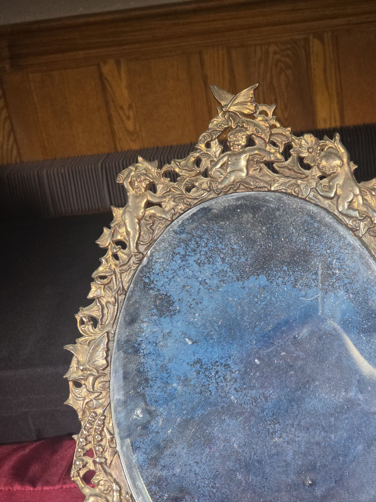 Antique Cast Brass Oval Mirror with Figural Cherub and Floral Surround