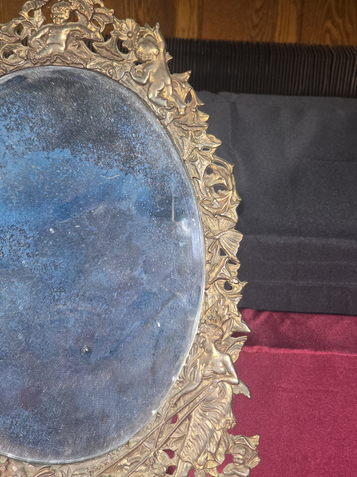 Antique Cast Brass Oval Mirror with Figural Cherub and Floral Surround