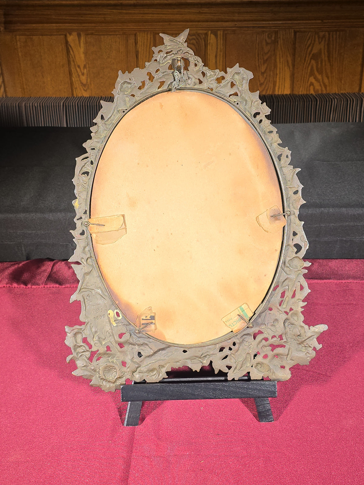 Antique Cast Brass Oval Mirror with Figural Cherub and Floral Surround