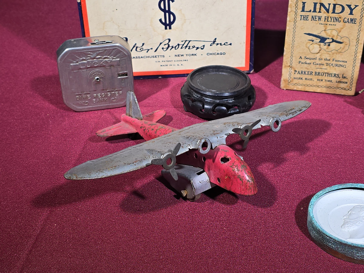 Grouping of Antique and Vintage Toys and Collectibles including Monopoly Game, "Lindy" Flying Card Game, Metal Airplane, Wooden Pull Toy, and Dime Register Bank