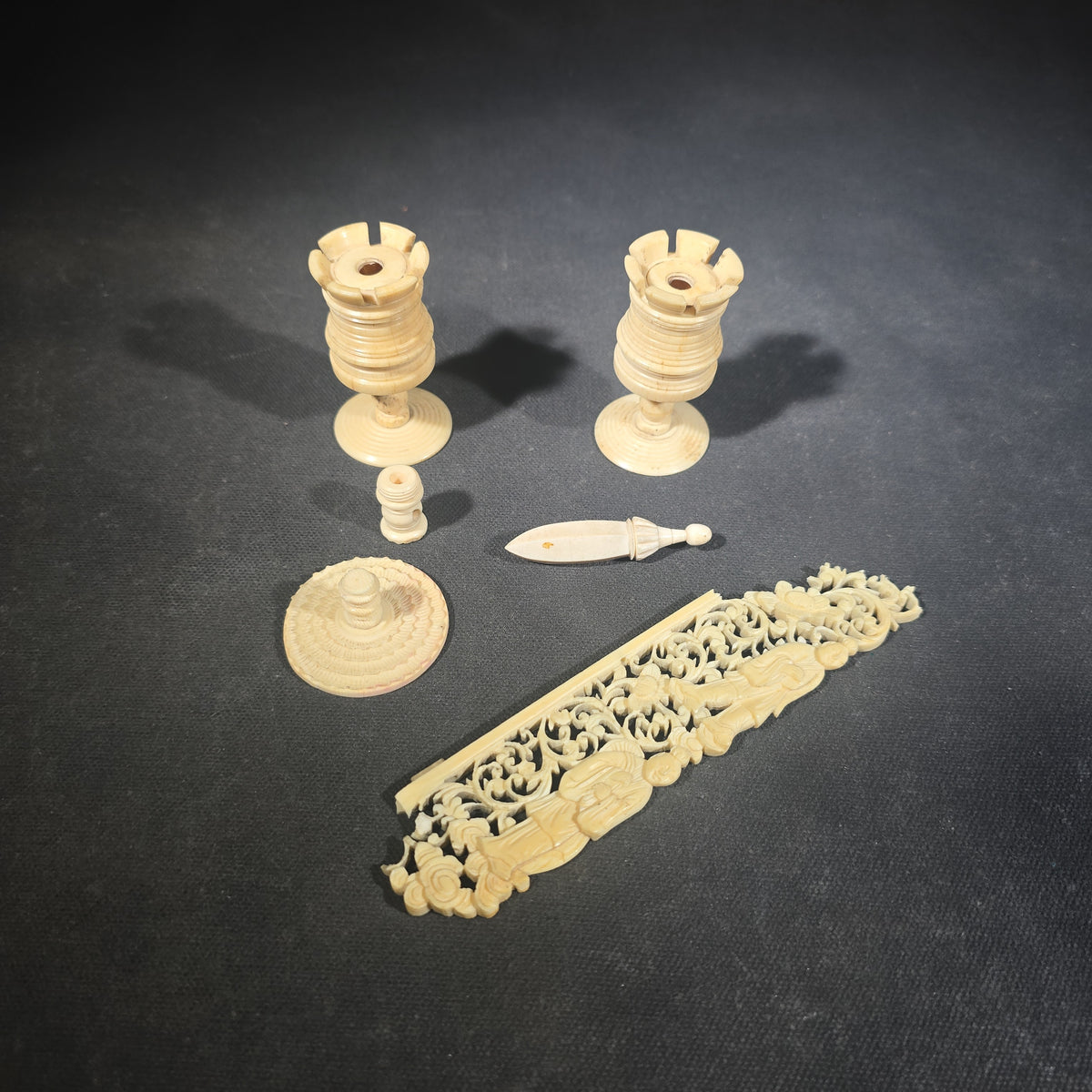 Grouping of Five Antique Carved Bone Pieces including Pair of Turned Rook Chess Pieces, Openwork Figural Panel, Turned Disc, and Turned Shuttle