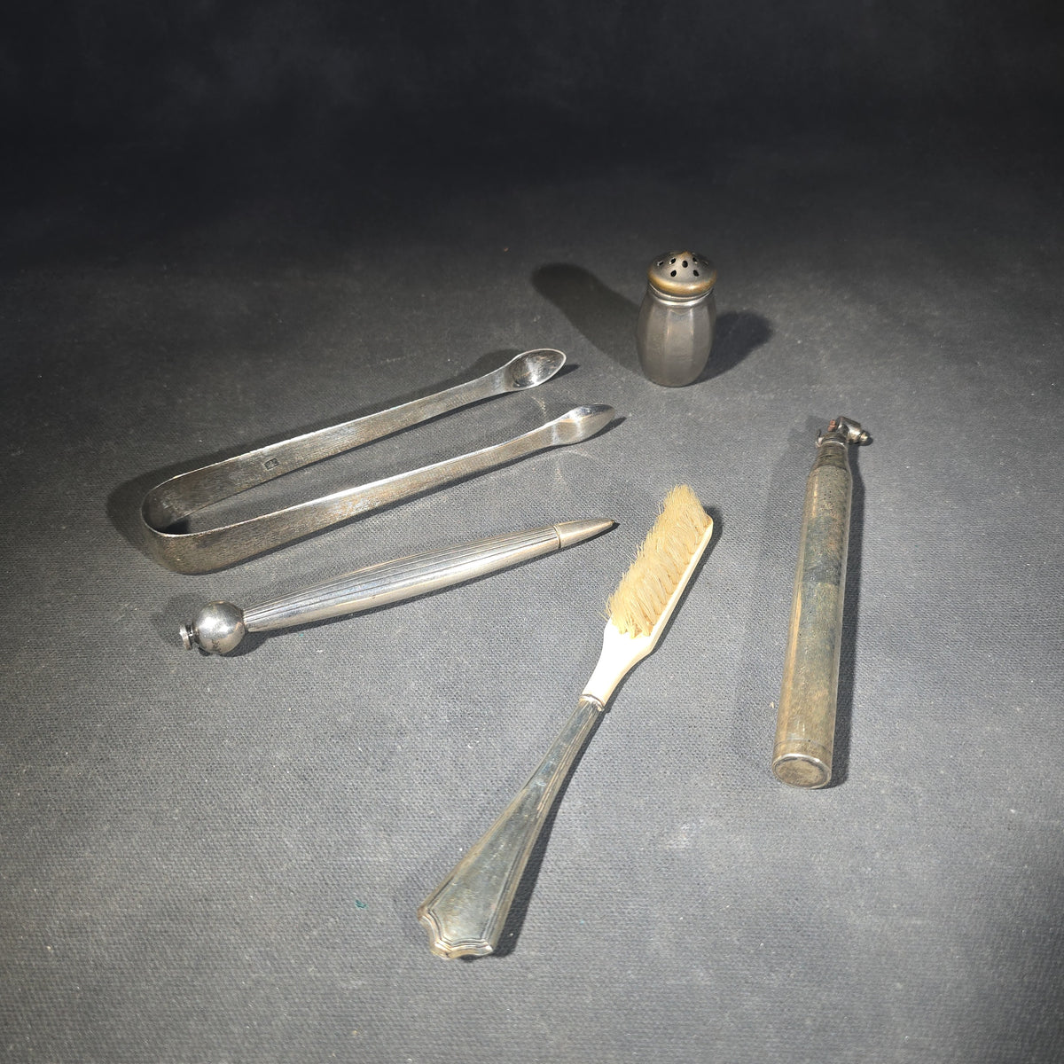 Grouping of Five Antique and Vintage Sterling Silver and Silver-Plated Objects including Sugar Tongs, Retractable Pencil, Sterling-Handled Toothbrush, Cylindrical Device, and Miniature Shaker