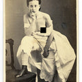 Lot 015 - Antique Risque Carte De Visite C.D.V. Photograph of a Seated Young Woman with Exposed Breast, Draped in White Fabric with Foot Resting on a Chair