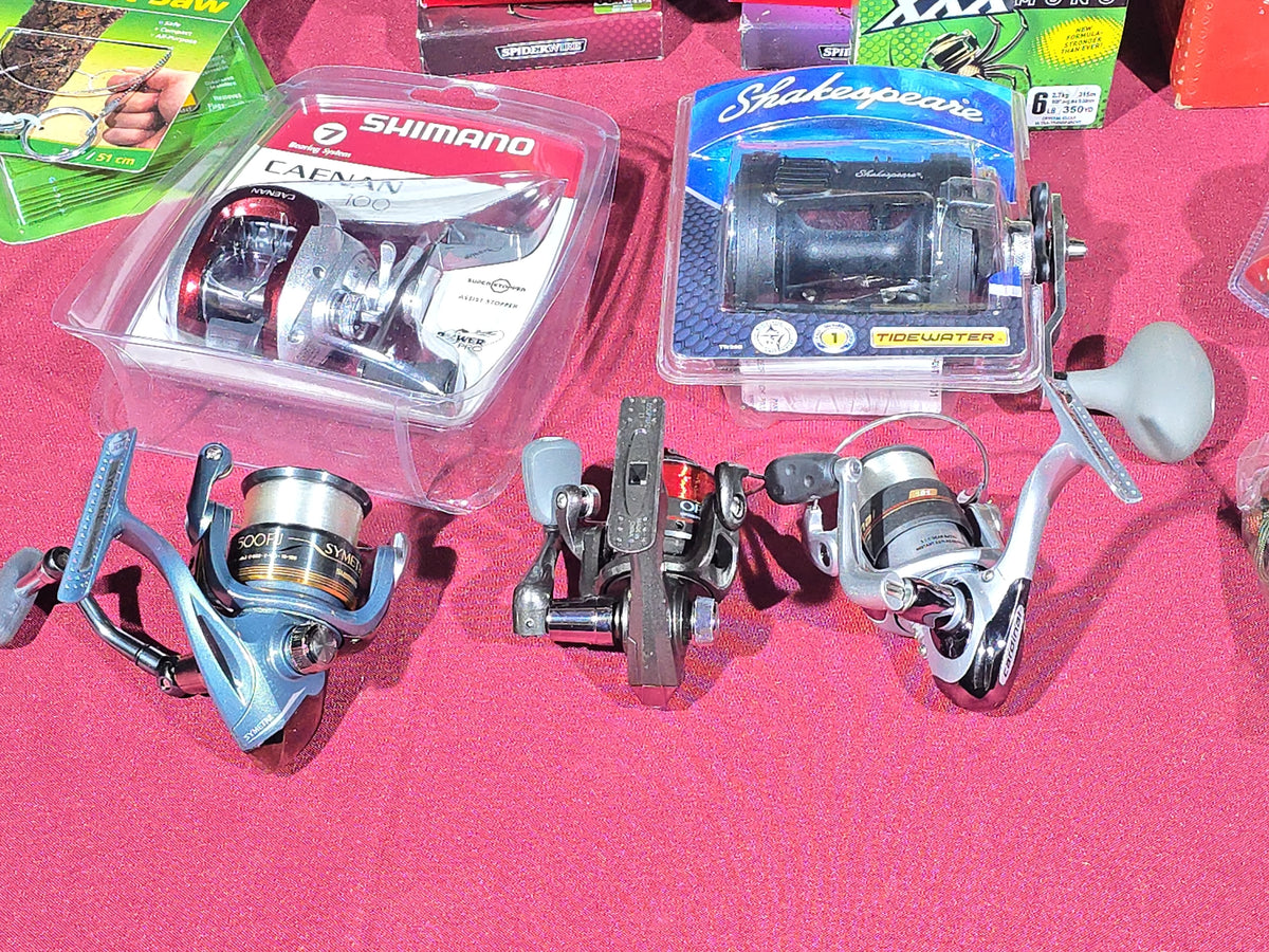 Grouping of Modern Fishing Reels, Line, and Tackle including Shimano Caenan 100, Shakespeare Tidewater, Quantum, and Penn Reels