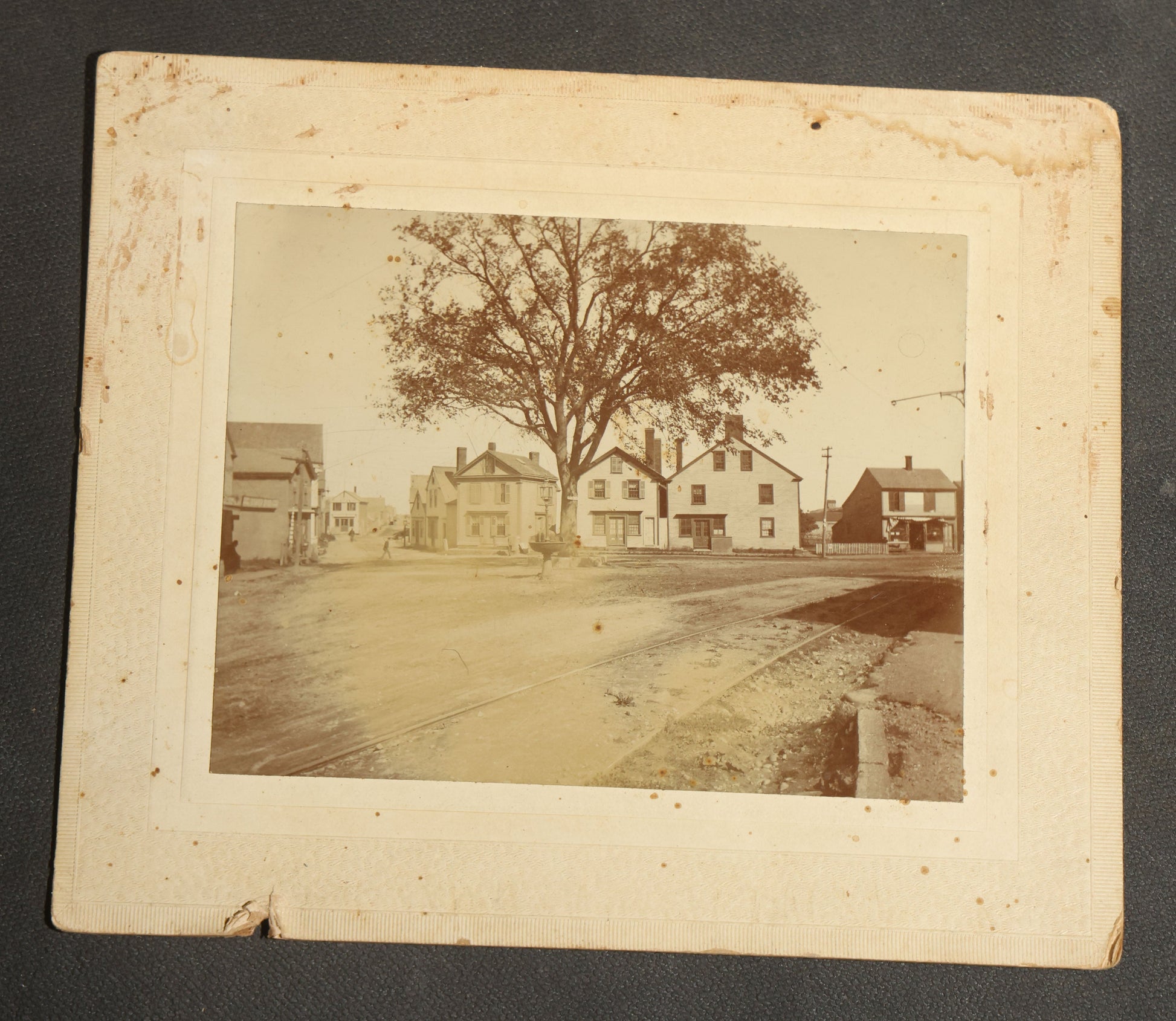 Grouping of Seven Antique Board-Mounted Photographs Including a Church, Street Scene, Couple's Portrait, Family Gathering, School Group, Early Automobile, and Parlor Interior with Telephone