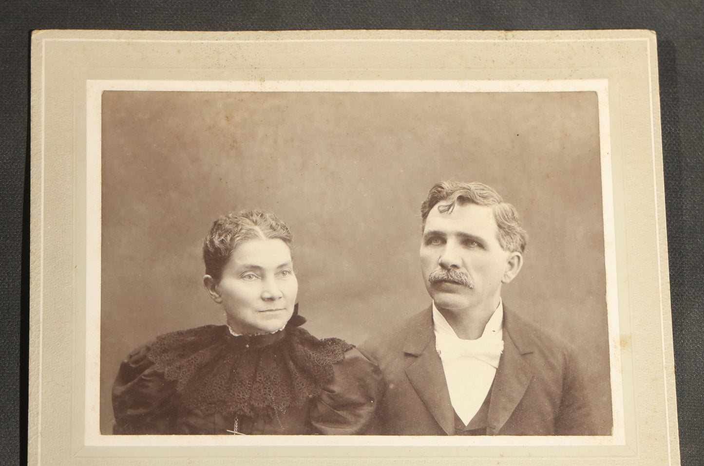 Grouping of Seven Antique Board-Mounted Photographs Including a Church, Street Scene, Couple's Portrait, Family Gathering, School Group, Early Automobile, and Parlor Interior with Telephone