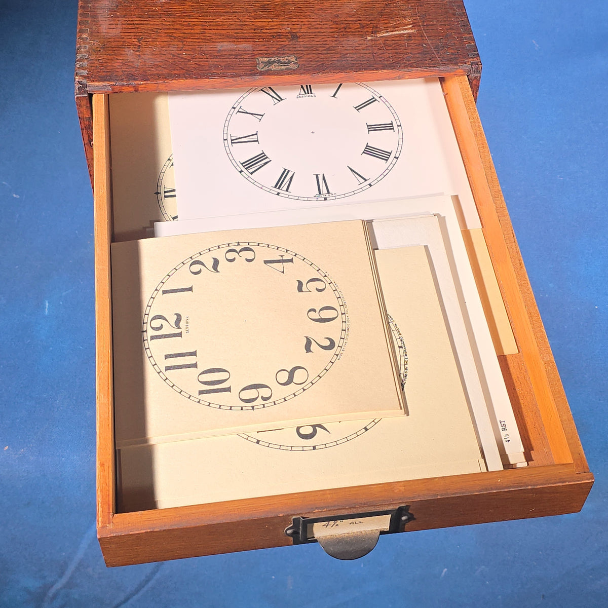 Vintage Oak Five-Drawer Cabinet with Clock Repair Paper Dial Faces including Ansonia, Sessions, and Ingraham