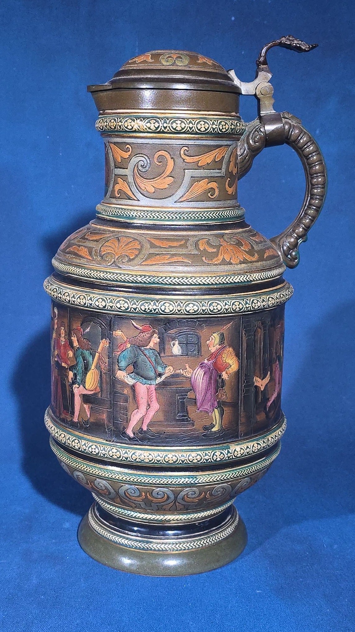 Grouping of Six Antique German Pottery Steins and Lidded Pitcher with Tavern Scenes, Stamped Germany