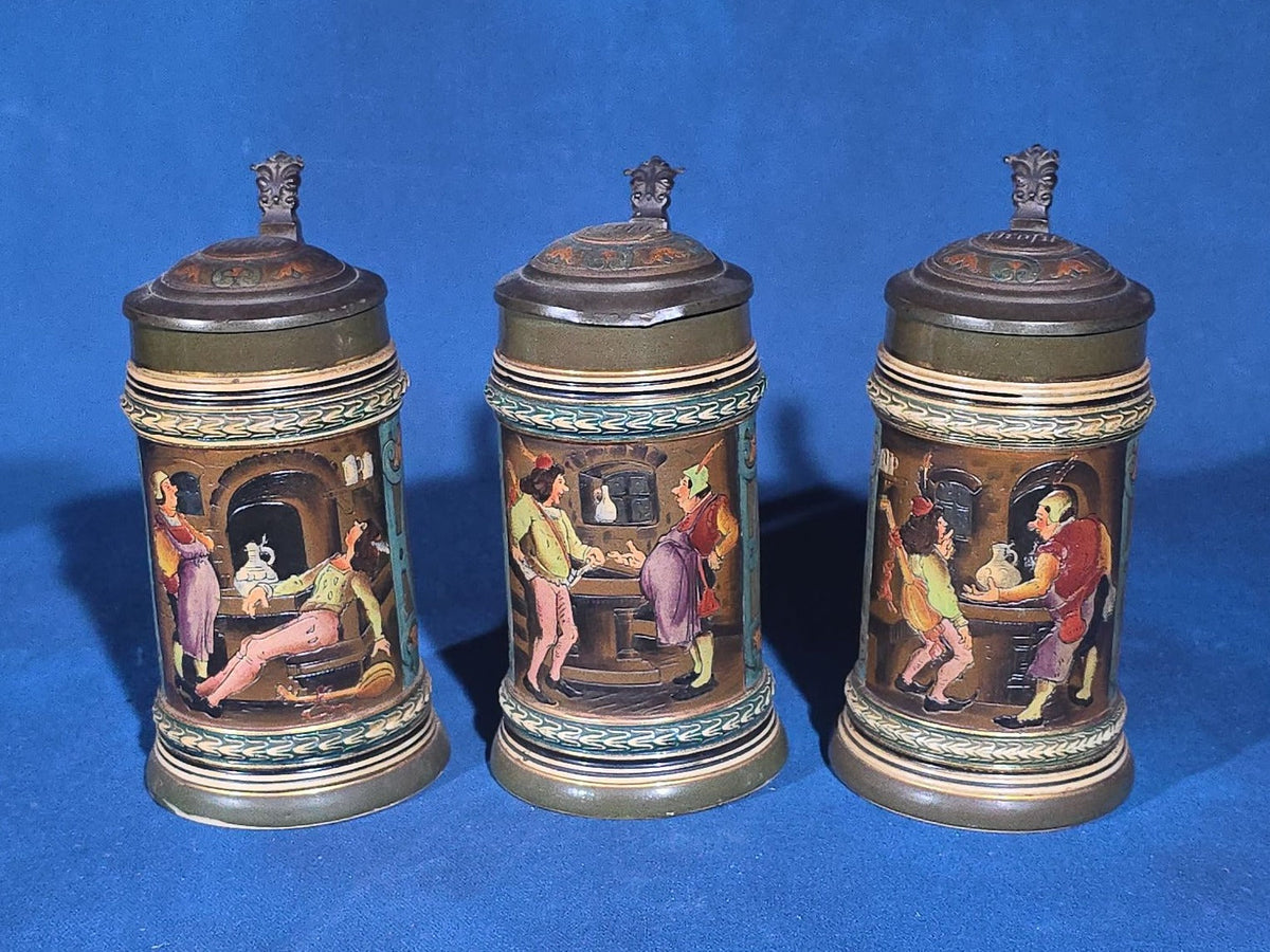Grouping of Six Antique German Pottery Steins and Lidded Pitcher with Tavern Scenes, Stamped Germany