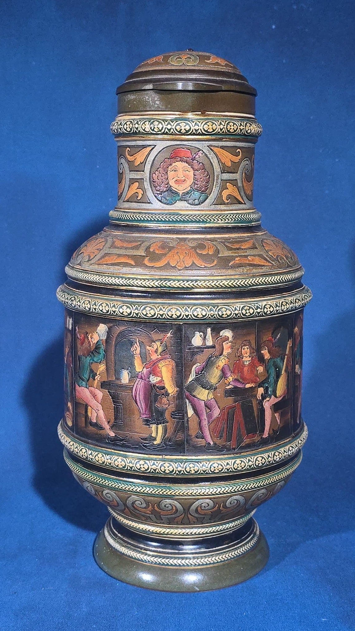 Grouping of Six Antique German Pottery Steins and Lidded Pitcher with Tavern Scenes, Stamped Germany