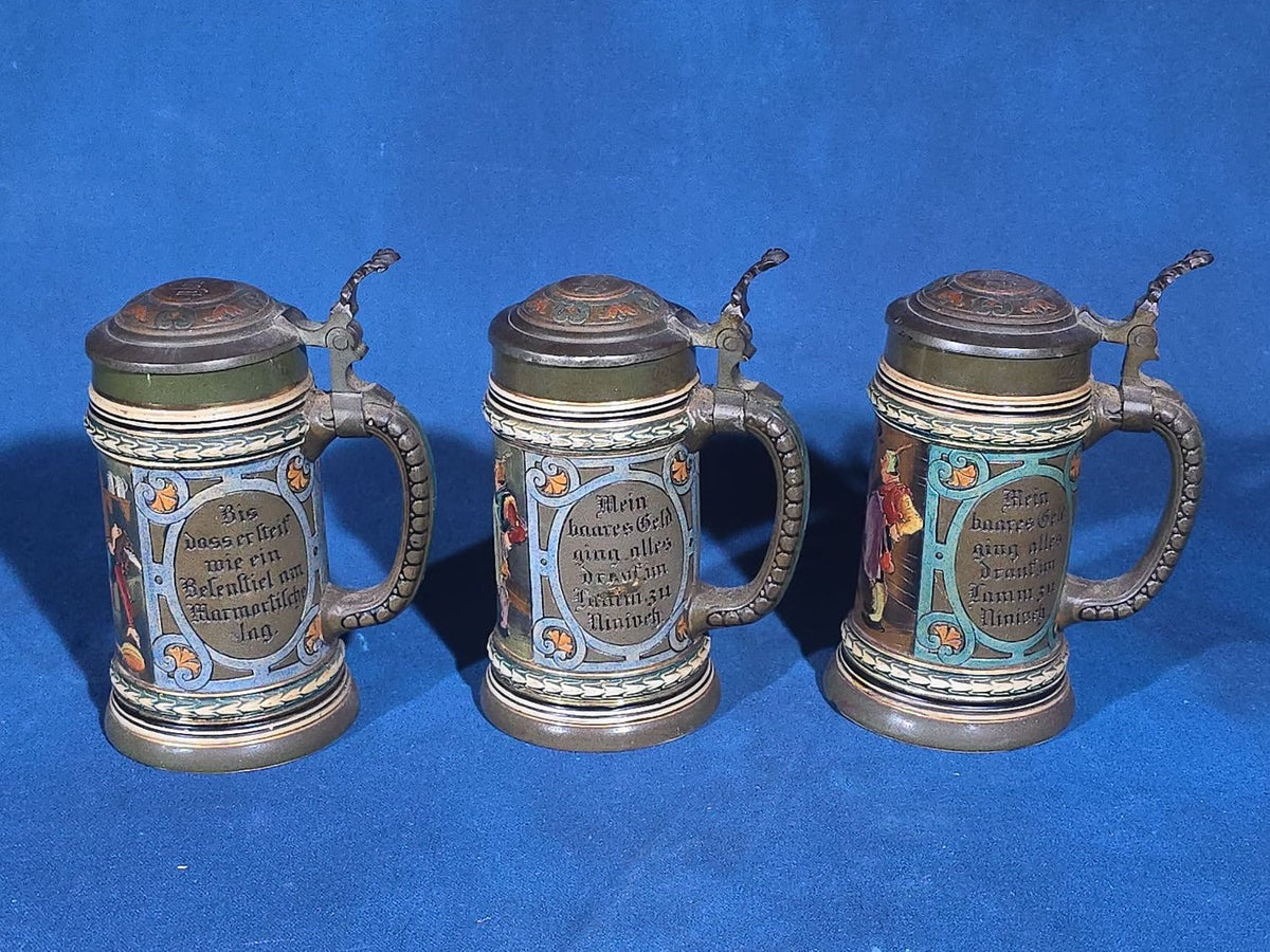 Grouping of Six Antique German Pottery Steins and Lidded Pitcher with Tavern Scenes, Stamped Germany