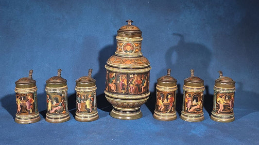 Grouping of Six Antique German Pottery Steins and Lidded Pitcher with Tavern Scenes, Stamped Germany