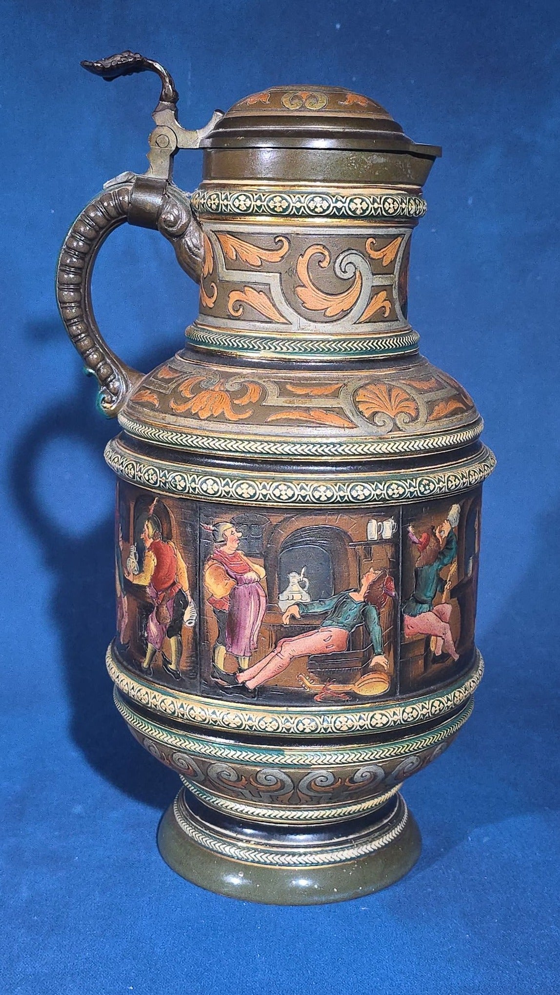 Grouping of Six Antique German Pottery Steins and Lidded Pitcher with Tavern Scenes, Stamped Germany