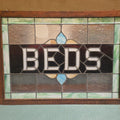 Lot 044 - Antique Leaded Stained Glass "Beds" Trade Sign, Reportedly from a Boston, Massachusetts Boarding House, Note Damage, 43-1/4" L x 31-1/4" H